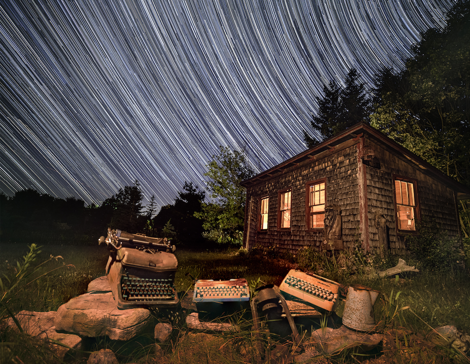 Norb Blei's Coop and typewriters at night with time-lapse stars in the background